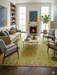 8' x 10' Rectangle Mustard Yellow & Light Blue Distressed Vintage Washable Area Rug styled in a cozy living room with mid-century chairs, a wooden coffee table, and a fireplace centerpiece.
