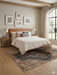 8' x 10' Rectangular Beige & Charcoal Tribal Medallion Vintage Area Rug styled in a bedroom with a leather headboard, soft bedding, and natural light.