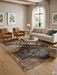 8' x 10' Rectangular Beige & Charcoal Tribal Medallion Vintage Area Rug styled in a living room with a neutral sofa, leather chairs, and warm wood accents.