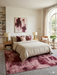8' x 10' Rectangular Blush & Burgundy Distressed Abstract Modern Area Rug styled in a bedroom with neutral bedding and warm wood furniture.