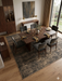 8' x 10' Rectangular Brown & Beige Distressed Abstract Modern Washable Area Rug styled in a dining room with a table and chairs.