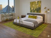 8' x 10' Rectangular Olive Gold Distressed Medallion Traditional Washable Area Rug placed in a modern bedroom with a gray upholstered bed, white bedding, and olive accent decor.