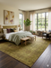 8' x 10' Rectangular Olive Gold & Purple Distressed Vintage Traditional Area Rug styled in a bedroom with layered bedding and natural light.