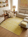 8' x 10' Rectangular Yellow Floral Distressed Traditional Area Rug styled in a warm living room with neutral sofas, wooden coffee table, and decorative shelving.