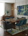 8' x 12' Rectangular Blue & Green Distressed Floral Vintage Washable Area Rug placed in a sophisticated dining room beneath a wooden dining table.