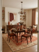 8' x 12' Rectangular Rust Orange & Ivory Floral Traditional Washable Area Rug styled in a dining room with a wooden table and chairs.