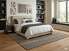 8' x 8' Square Ivory Charcoal Grid Modern Washable Area Rug placed under a bed in a modern bedroom with layered white and gray bedding.