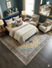 8' x 8' Square Ivory & Navy Blue Floral Medallion Traditional Area Rug styled in a sophisticated bedroom with a navy upholstered bed and cream bedding.