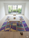8' x 8' Square Purple Multi Color Wavy Striped Modern Washable Area Rug styled in a dining room with a simple wood table and modern chairs.