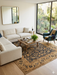 8' x 8' square gold & black floral medallion traditional area rug placed in a bright living room with a neutral sofa, wood coffee table, and large windows.